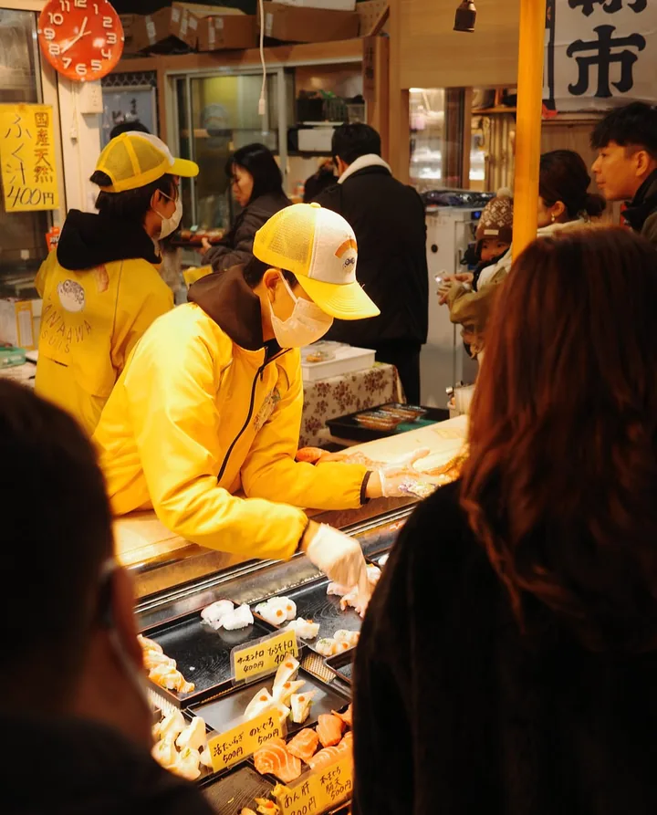 A stallholder serving customers at Karato fish market